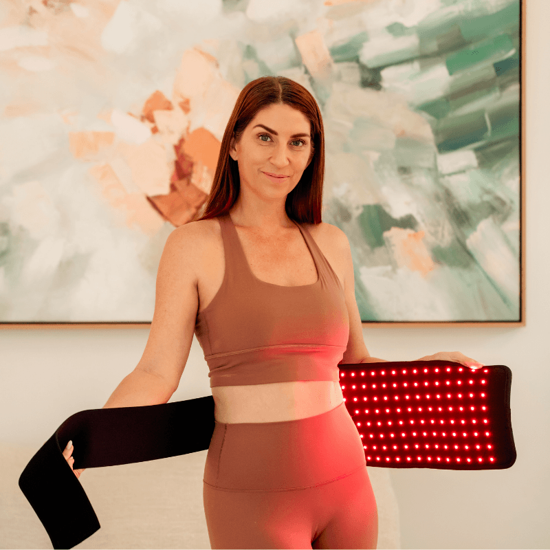 a woman using a Red Light Therapy Belt PRO on her waist