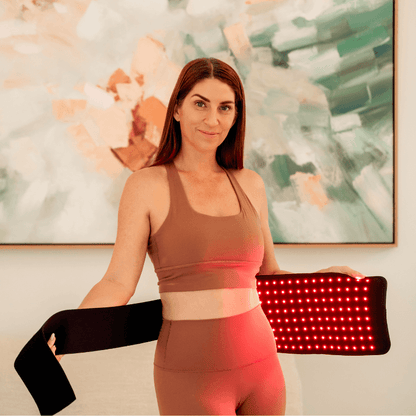a woman using a Red Light Therapy Belt PRO on her waist