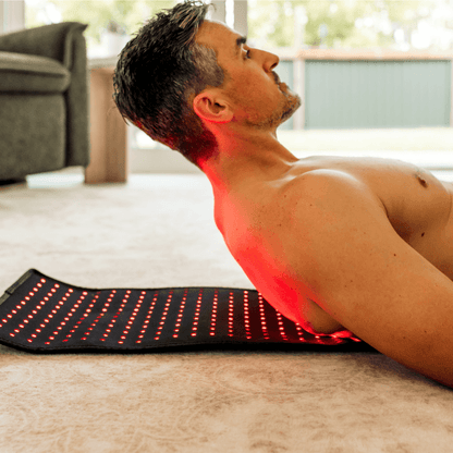 a man lying on XL Red Light Therapy Pad