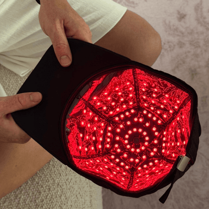 Close-up inside the EliteRelief red light therapy cap showing the full array of red LEDs lit up