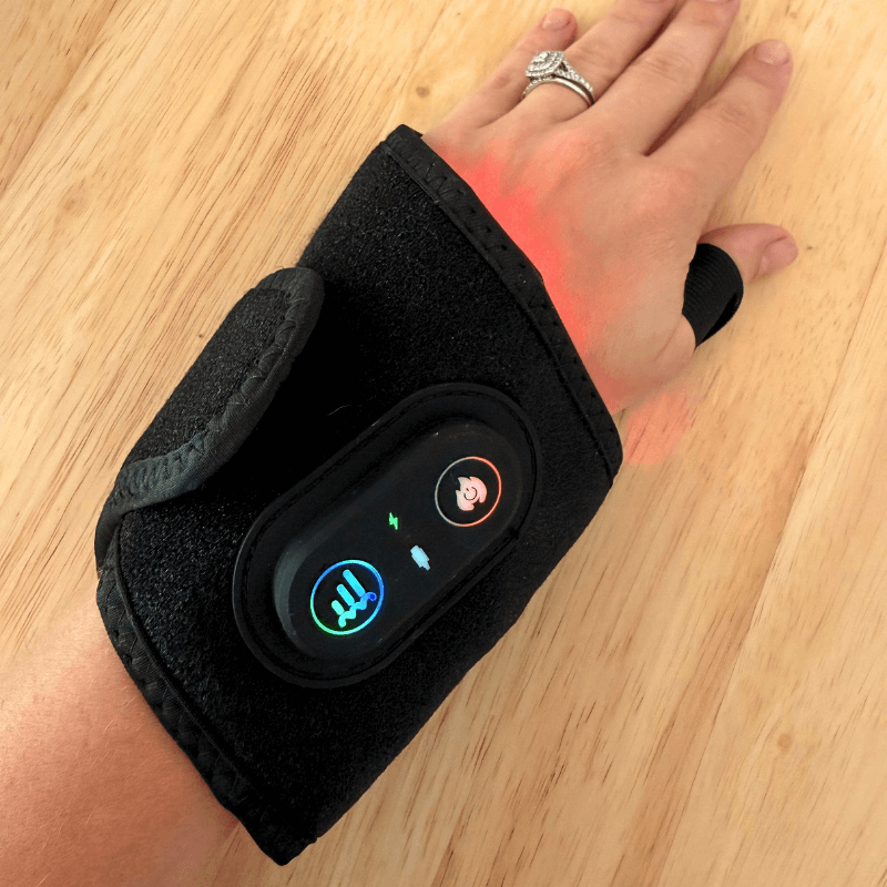 Black wrist brace with digital display on a wooden surface