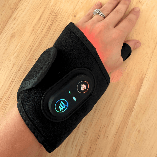 Black wrist brace with digital display on a wooden surface